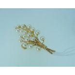 A 14k yellow gold Brooch, formed of a twig set with multiple cultured pearls, 2½in (6.5cm) long.