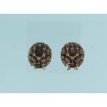 A pair of 14k yellow gold Clip Earrings, of oval bombe form, set with faceted garnets (2)
