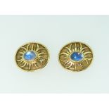A pair of 18k yellow gold Clip Earrings, of oval form, with a textured ground with polished sun