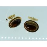 A pair of 14k yellow gold Cufflinks, of oval form, the plain border with cabouchon Tiger's Eye,