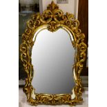 A large giltwood Rococo style mirror, with an elaborate scroll-moulded frame, 141 x 89cm