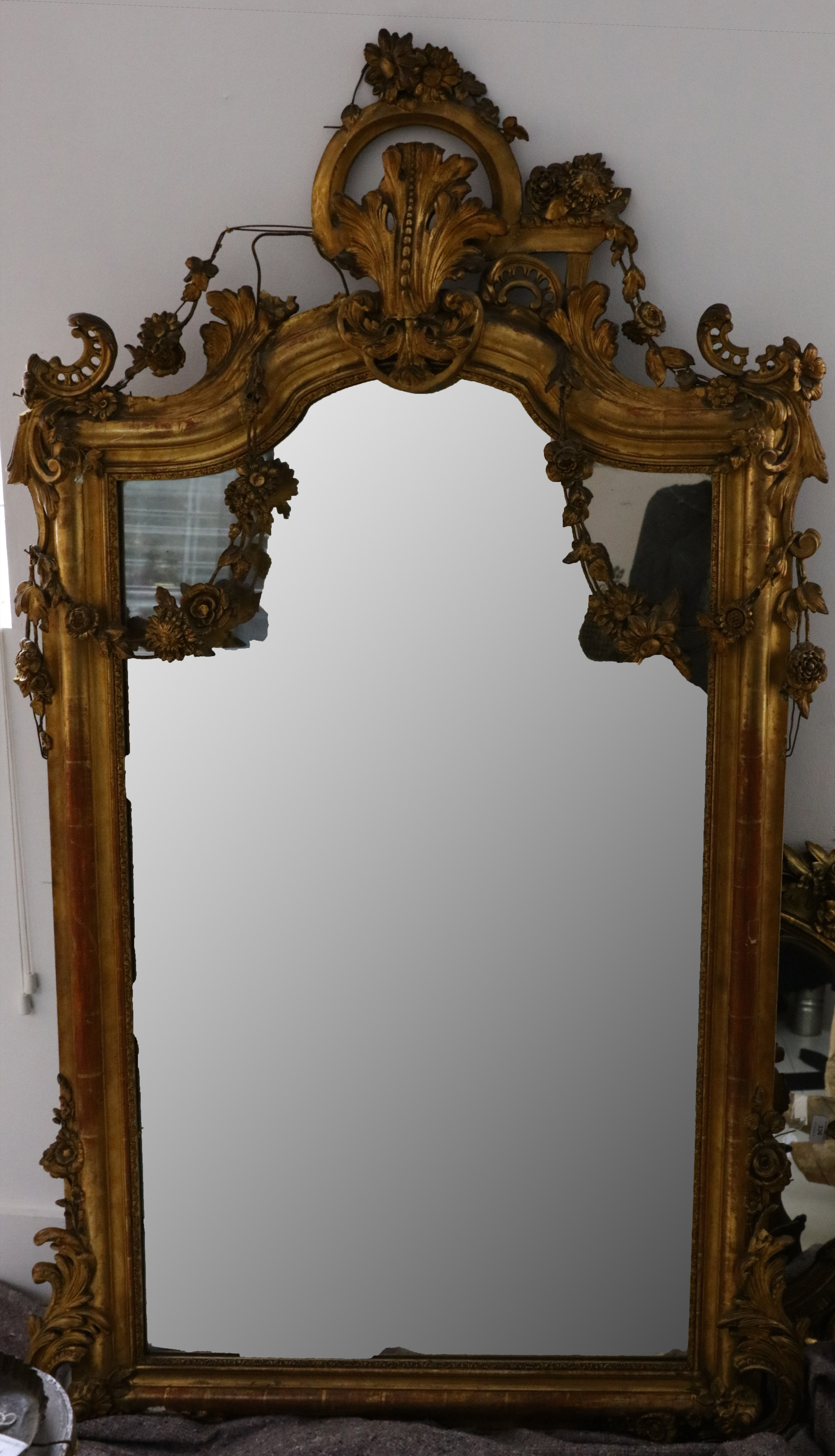 A large giltwood Rococo style mirror, with acanthus scroll moulding and floral swags, 172 x 98cm (