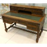 An Edwardian oak desk, early 20th century, with a gallery of drawers over main desktop set with an