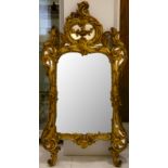 An attractive giltwood Rococo style mirror, with a scroll-moulded frame, 132 x 69cm