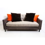 A Finchatton two seater sofa, with grey nappa leather and beige upholstery, on ebonised legs, 200