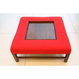 A modern bespoke made coffee table by Coryndon, in dark stained wood with red fabric upholstered