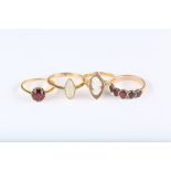 A group of four rings, including two garnet-set rings, a 22ct gold shell cameo ring, and a 9ct