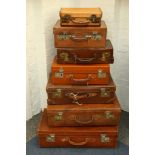 A collection of tan leather toilet cases and suitcases, early to mid-20th Century, with brass,