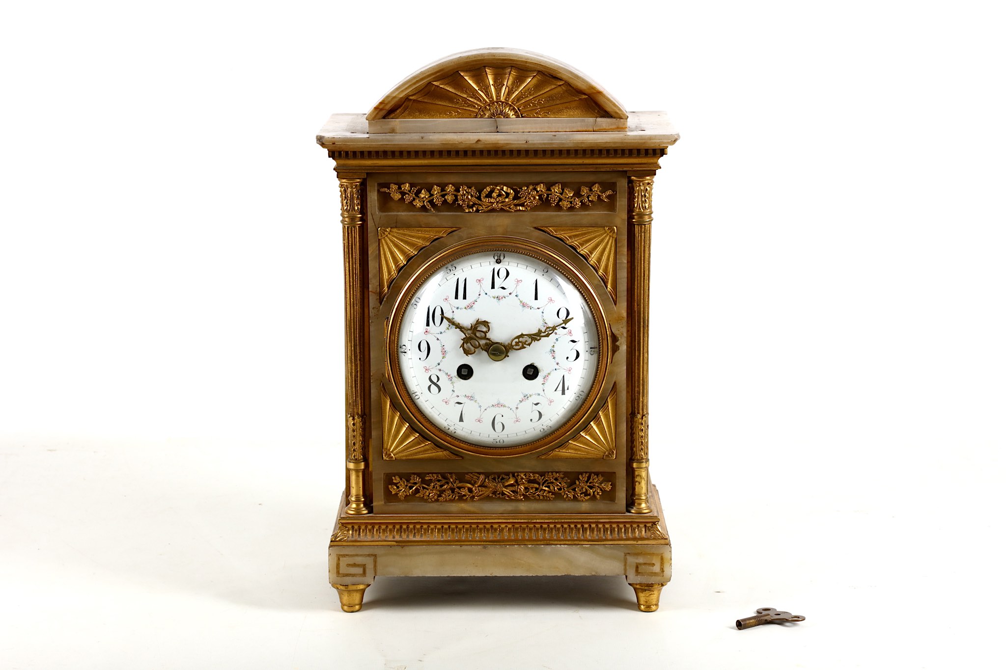 A French gilt bronze mounted alabaster mantel clock, 19th Century, the floral tablet, paterae column