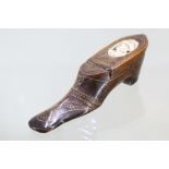 A Continental wooden shoe, mid-19th century, decorated with brass stud-work and a carved bone head
