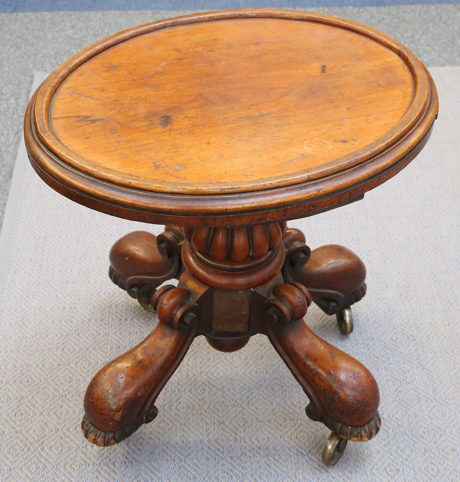 A small Victorian oval mahogany table, 19th Century, with a raised half-edge set onto a heavily