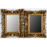 A near pair of Florentine carved giltwood wall mirrors, late 19th or early 20th century, the