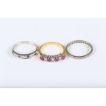 A group of three rings, including a diamond eternity ring, a sapphire and diamond half-hoop ring and