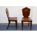 A pair of Victorian mahogany hall chairs, late 19th century, with applied cartouche backs on tapered