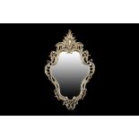 A SMALL ROCOCO STYLE GILT BRONZE WALL MIRROR the shaped frame surmounted by a cartouche flanked by