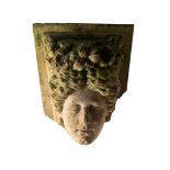 A 19TH CENTURY KEYSTONE, PROBABLY COADE STONE modelled as a female mask with floral headdress,  47cm