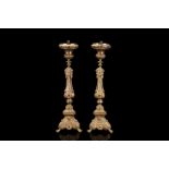 A PAIR OF BAROQUE STYLE GILT BRASS TORCHERES  the faceted stems with scrolling acanthus leaf