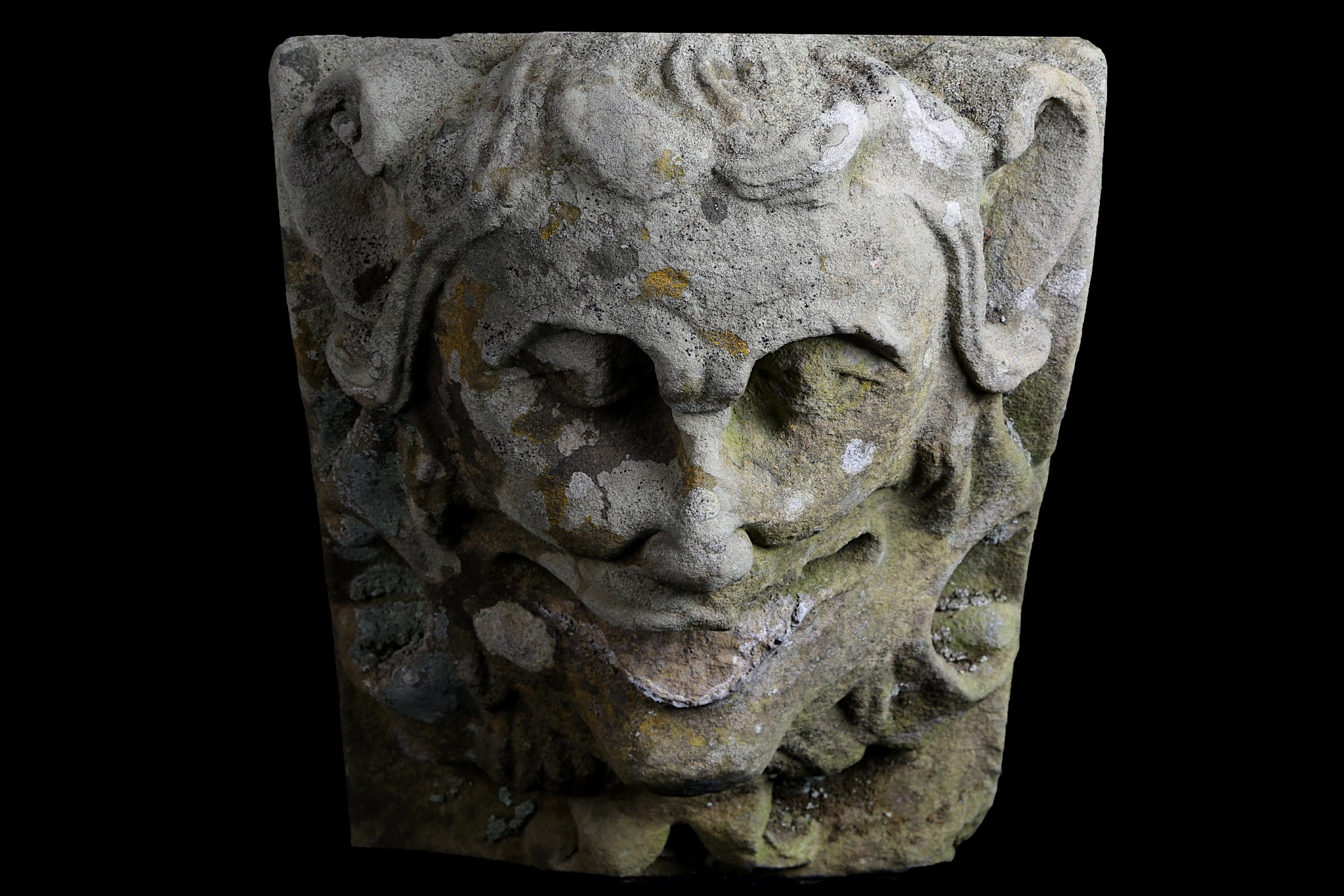 A FIRST HALF 19TH CENTURY CARVED SANDSTONE KEYSTONE DEPICTING A JESTER MASK the laughing face with