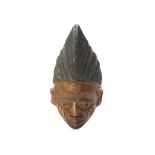 A YORUBA WOOD MASK, NIGERIA With a face that tapers to a pointed chin, the facial features are