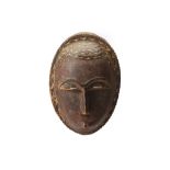 A SMALL YAURE MASK, IVORY COAST Of ovoid form, with half moon slit eyes and eyebrows in raised