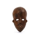 A WOOD MASK  With a very large bulbous forehead, the stylised face is flanked by small ears, 31.