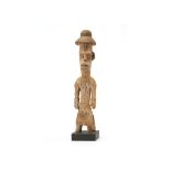 AN URHOBO MALE FIGURE, NIGERIA Standing on short legs, the figure wears a cloth skirt, cuffs on each