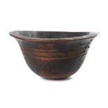 A LARGE AFRICAN WOOD BOWL  A deep bowl with a flat everted rim decorated with carved linear designs,