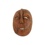A LARGE WOOD MASK With an enlarged ovoid head, the mask has eliptical hollow eyes surmounted by