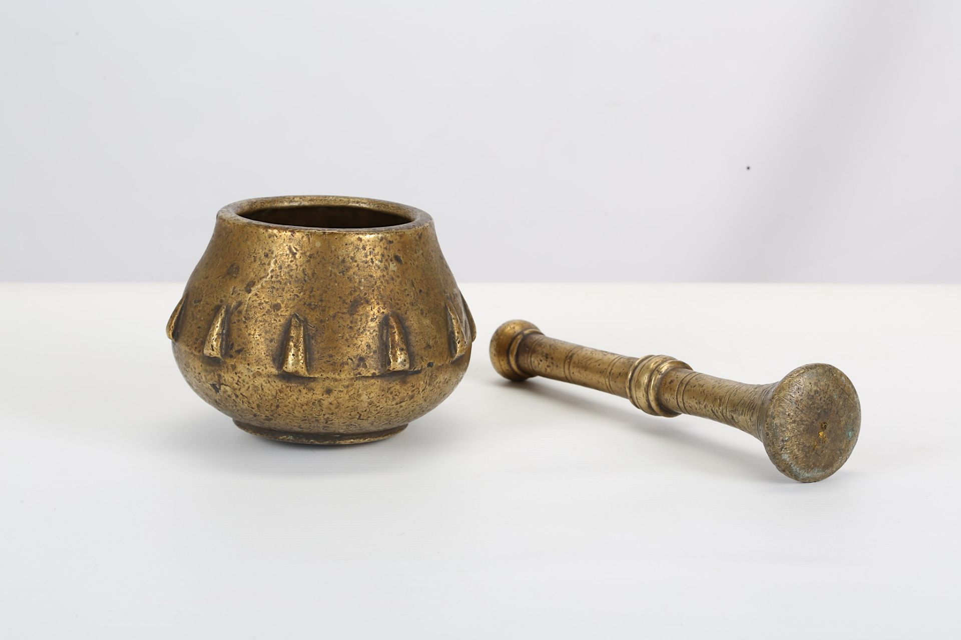 A BRASS MORTAR AND PESTLE Northern India, 18th century  The mortar of bulbous form with slightly - Image 2 of 3