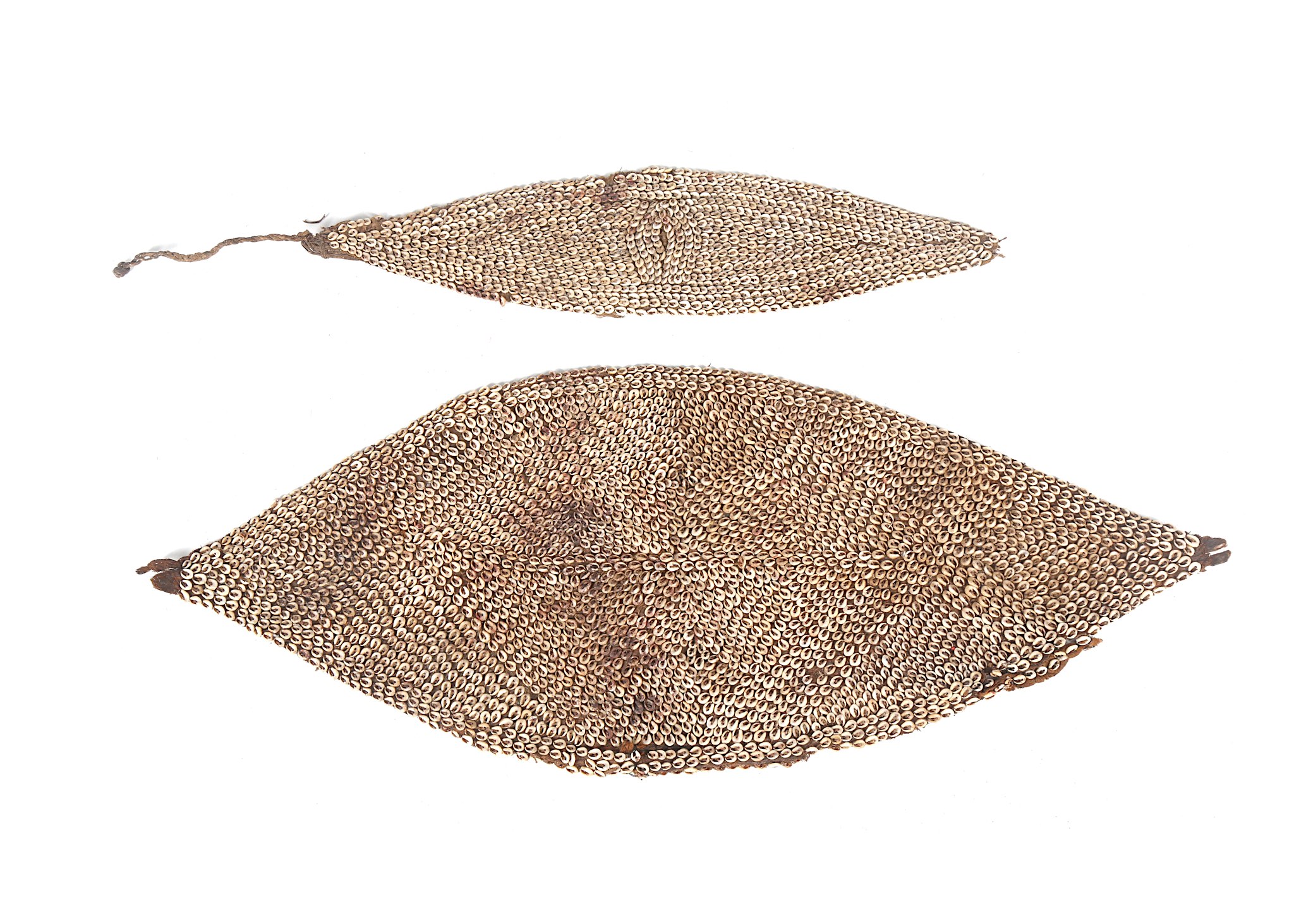 A group of ethnographic objects, including two leaf shaped head and body fibre ornaments for