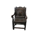 An English oak Wainscott armchair, mid-17th century, with a scroll carved crest rail over an