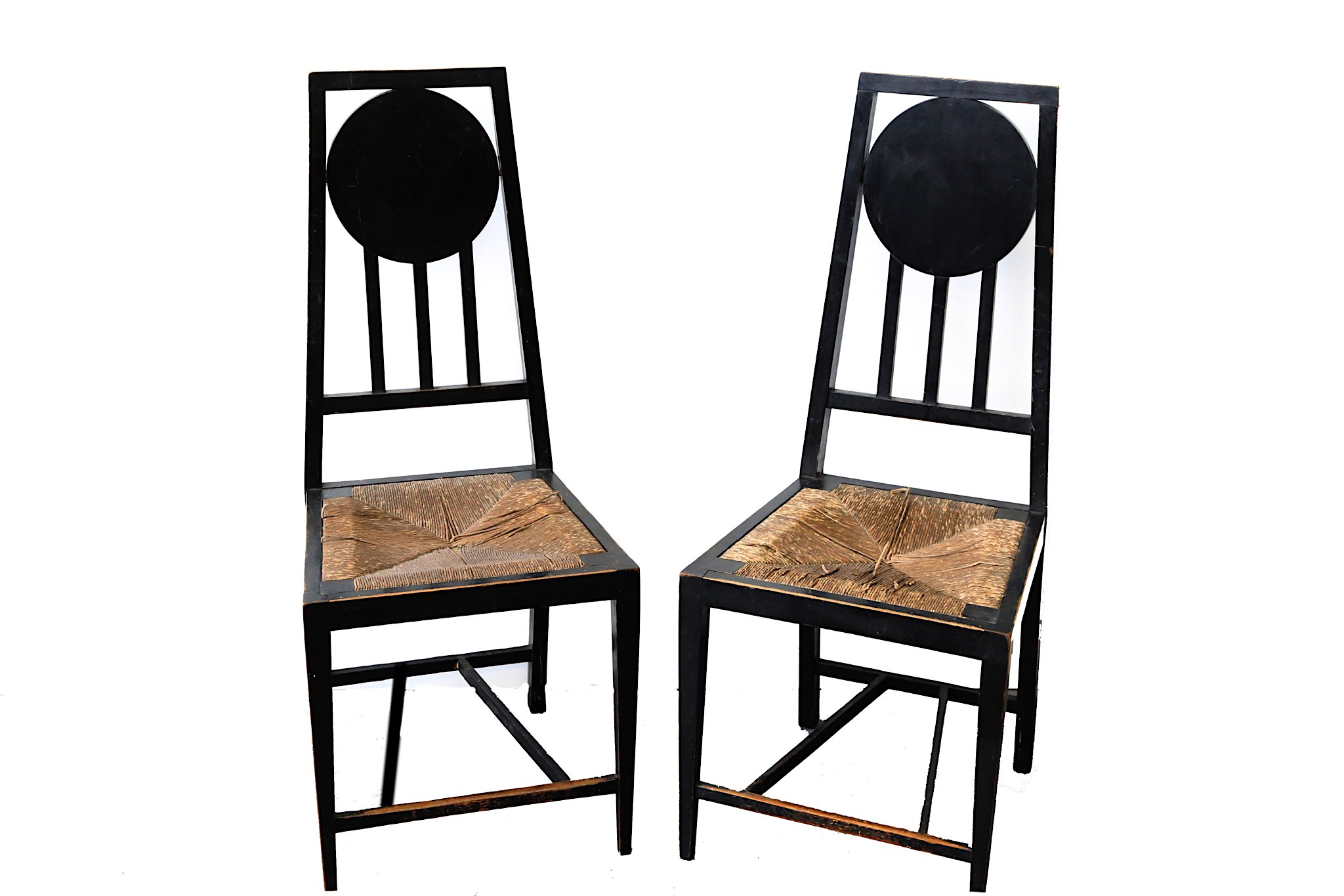 A pair of Mackintosh style ebonised side chairs, with drop in rush seats (2)