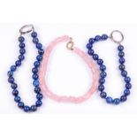 A group of three necklaces, two composed of lapis lazuli beads and one of barrel-shaped rose