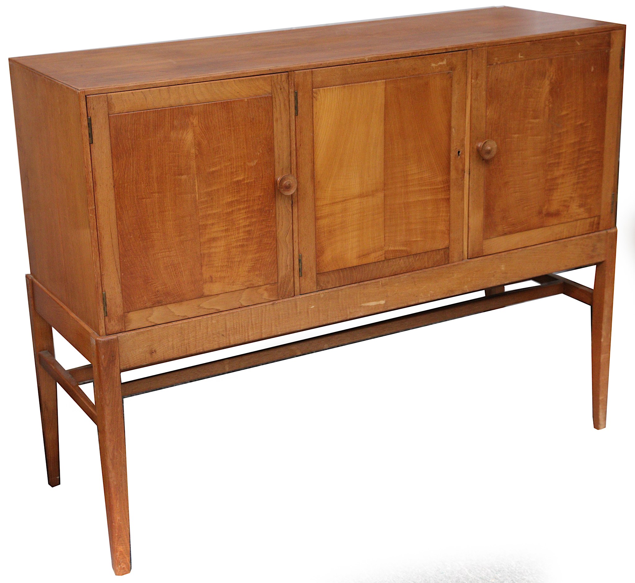 A Gordon Russell oak sideboard, the three paneled doors enclosing slides and shelves, on square