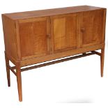 A Gordon Russell oak sideboard, the three paneled doors enclosing slides and shelves, on square