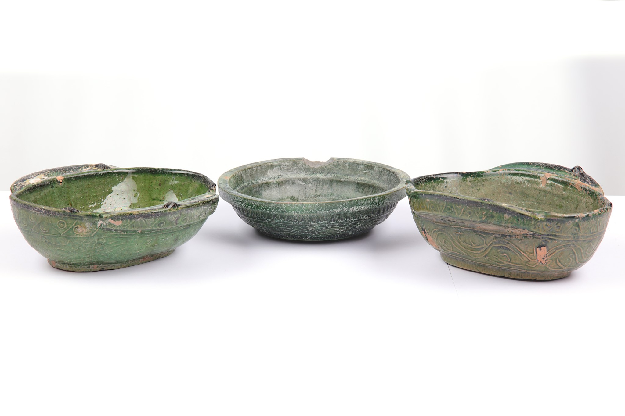 A pair of Chinese twin handled green glazed bowls,