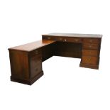 A reproduction Georgian design mahogany L-shaped desk, with leather inset top over four drawers,