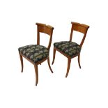 A pair of Biedermeier style elm side chairs, 20th century, with curved backs on sabre legs (2)
