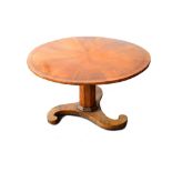 A Biedermeier style circular walnut breakfast table, the segmented veneered top on octagonal