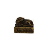 A CHINESE BRONZE ‘QILIN’ WEIGHT. Ming Dynasty. Cast as a seated the head turned to the left, the