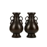 A PAIR OF CHINESE BRONZE VASES. Ming Dynasty. Each of pear shaped form, on a spreading foot and