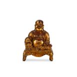 A CHINESE GILT-LACQUER BRONZE FIGURE OF BUDDHA. Ming Dynasty. The smiling, corpulent figure is