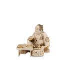 AN IVORY OKIMONO OF A MAN EATING. Meiji Period. Seated at a low table, holding a sake cup, a hibachi
