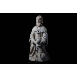 A 15TH CENTURY FRENCH GOTHIC CARVED LIMESTONE FIGURE OF A MAGI KING  the kneeling figure holding