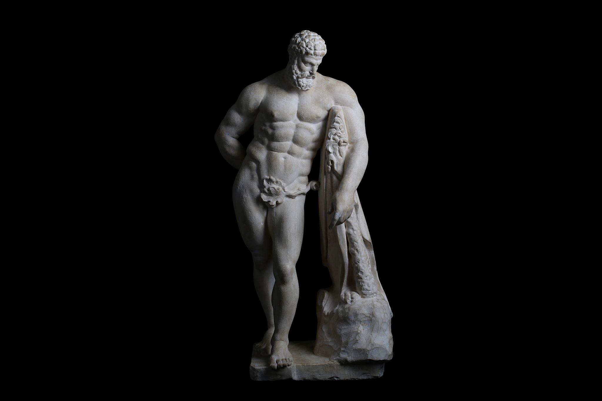 AN 18TH CENTURY CARVED LIMESTONE FIGURE OF THE WEARY HERCULES OF LYSIPPOS, AFTER THE ANTIQUE the