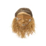 A FRINGED DANCE MASK, BAPENDE, CONGO With a wide flattened face, the mouth, cheeks and temples