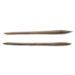 TWO ABORIGINAL CLUBS Both long clubs are ribbed and taper to points at both ends, 64.5 & 66.5cm