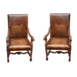 A pair of Carolean style walnut open armchairs, the brown leather upholstery with embossed