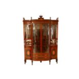 An Edwardian mahogany and satinwood bowfront display cabinet, the stepped cornice with turned urn