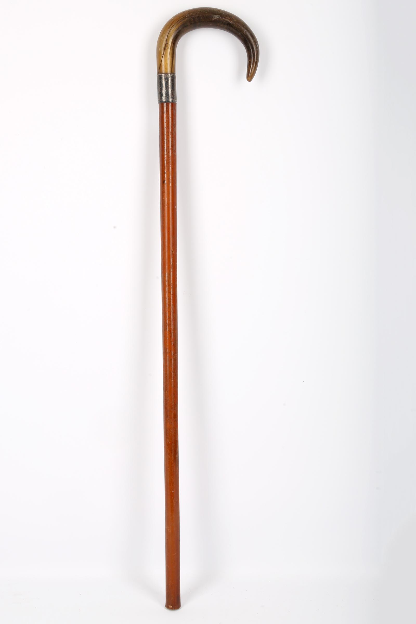 A rhinoceros horn handled walking stick, early 20th Century, with white metal mounts, 85cm long